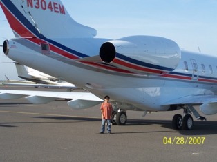 Tim behind private jet.